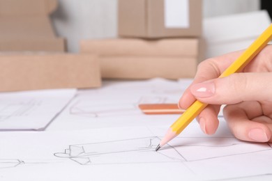 Photo of Woman creating packaging design at table, closeup