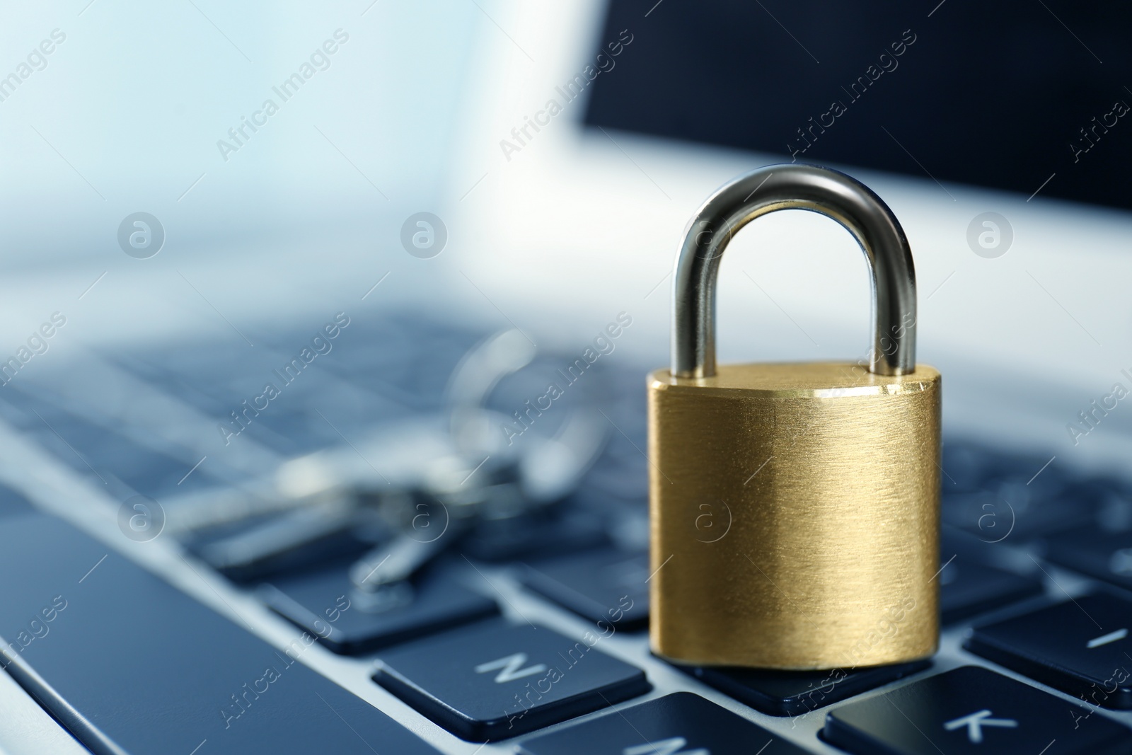 Photo of Metal padlock on laptop keyboard, space for text. Cyber security concept