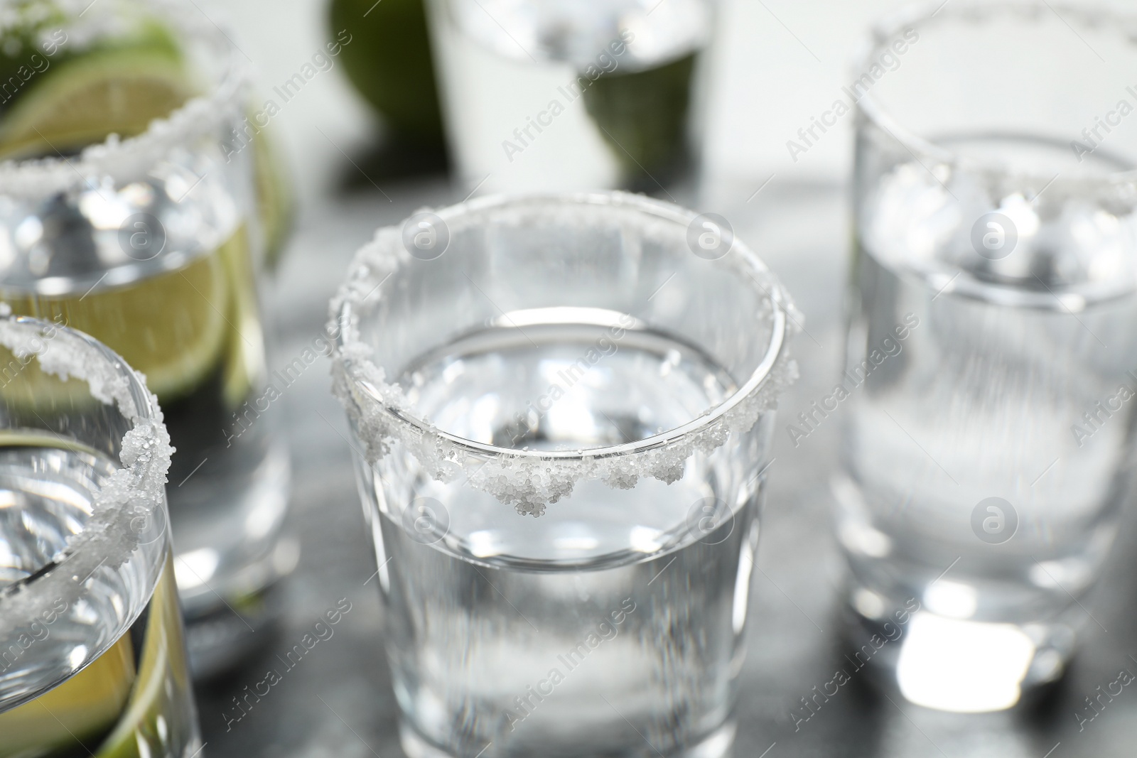 Photo of Mexican Tequila shots with salt on table, closeup