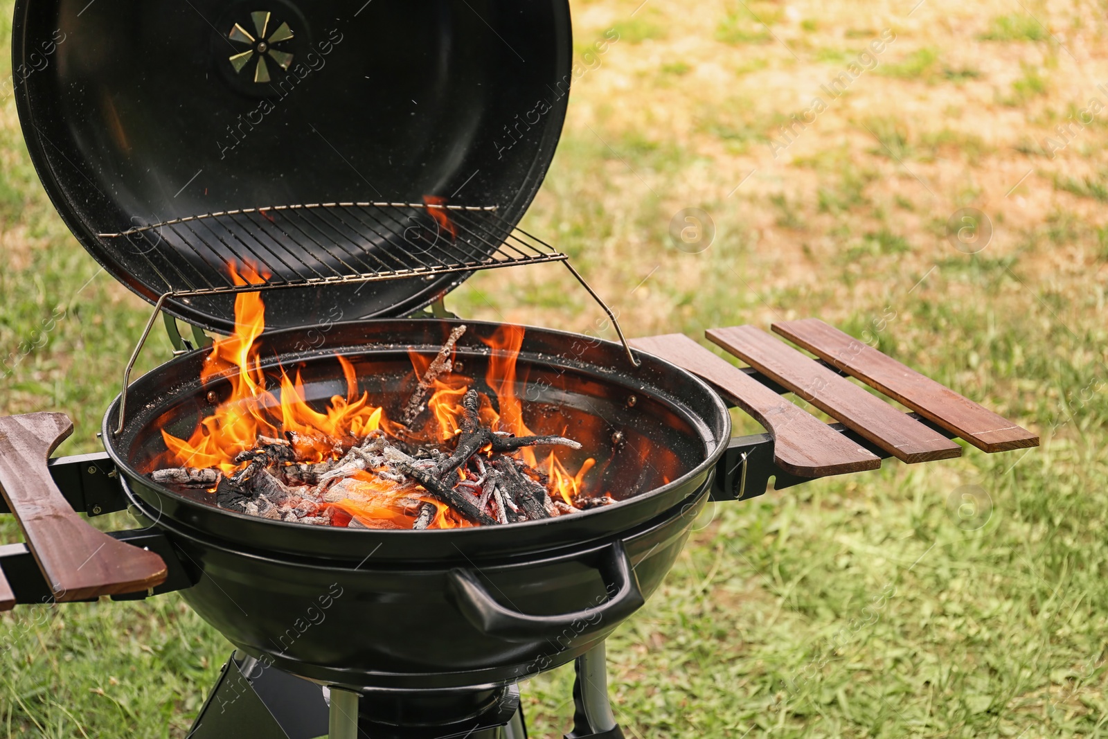 Photo of Modern barbecue grill with fire flames outdoors