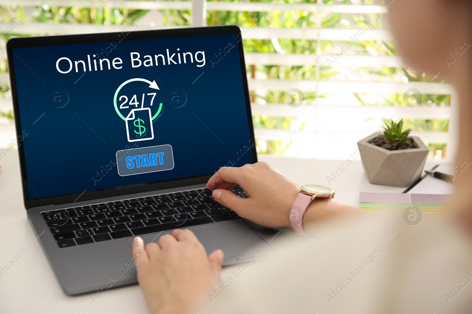 Image of Woman using online banking application on laptop at table, closeup