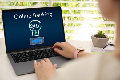 Image of Woman using online banking application on laptop at table, closeup