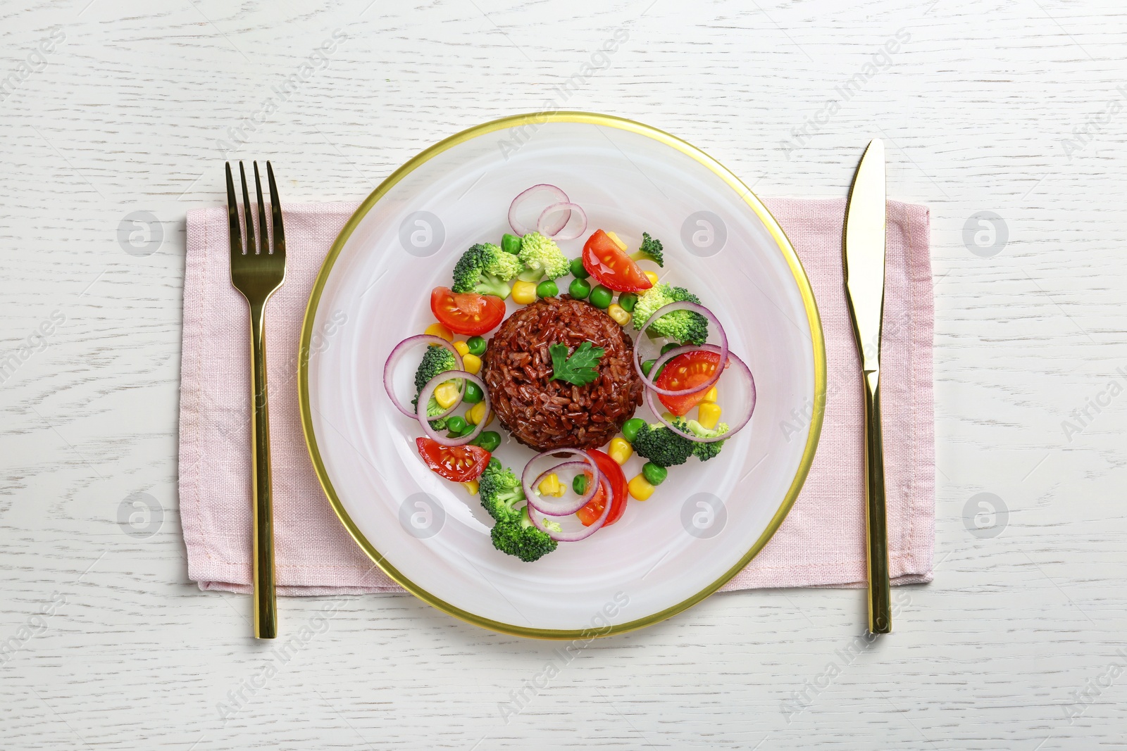 Photo of Plate of boiled brown rice with vegetables on served table, top view