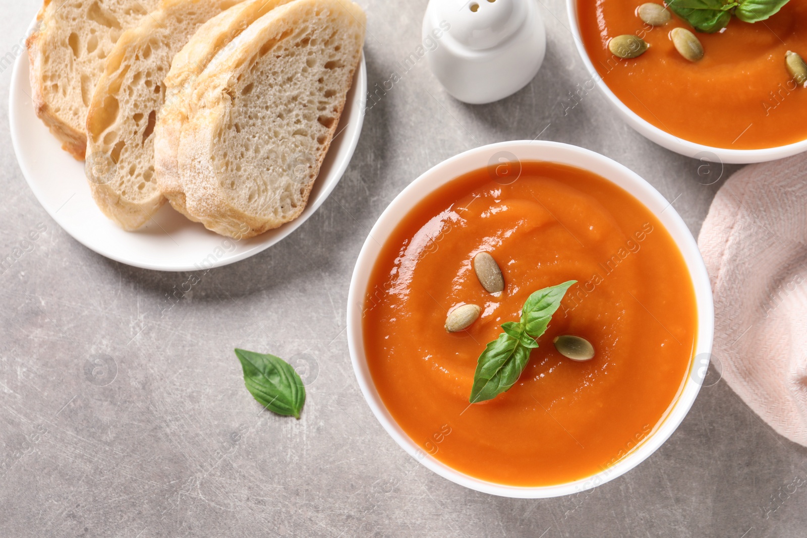 Photo of Flat lay composition with bowls of tasty sweet potato soup on grey background