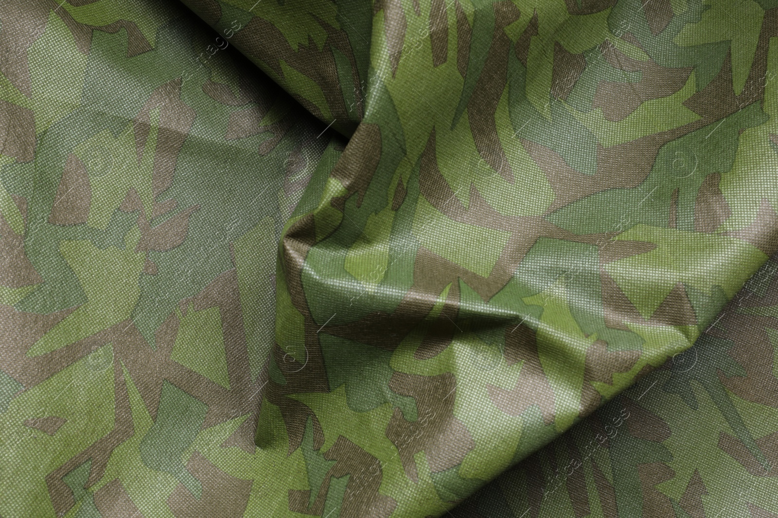 Photo of Texture of crumpled camouflage fabric as background, top view