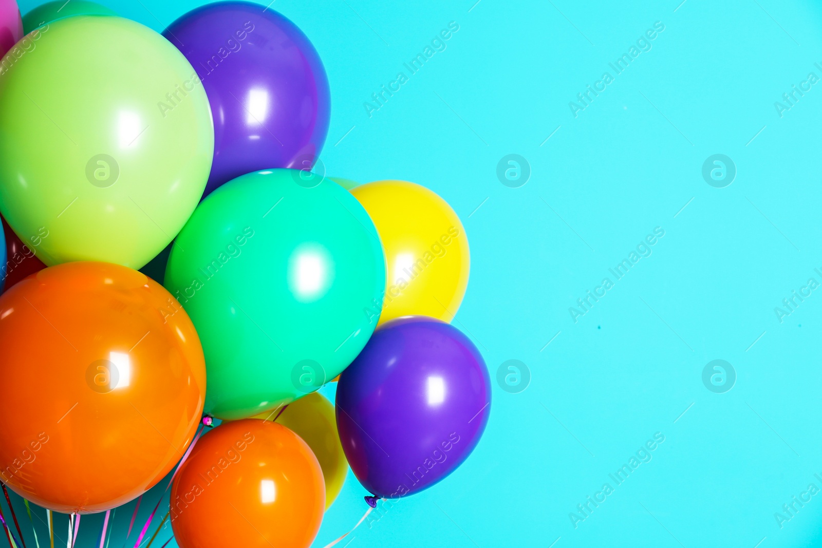 Photo of Bunch of bright balloons on color background with space for design