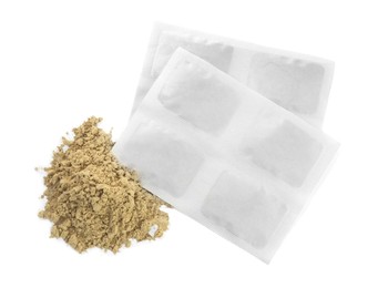 Photo of Mustard powder and plasters on white background, top view