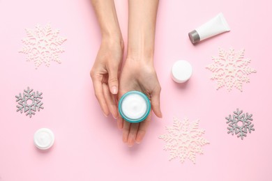 Photo of Woman with jar of hand cream at pink background, top view