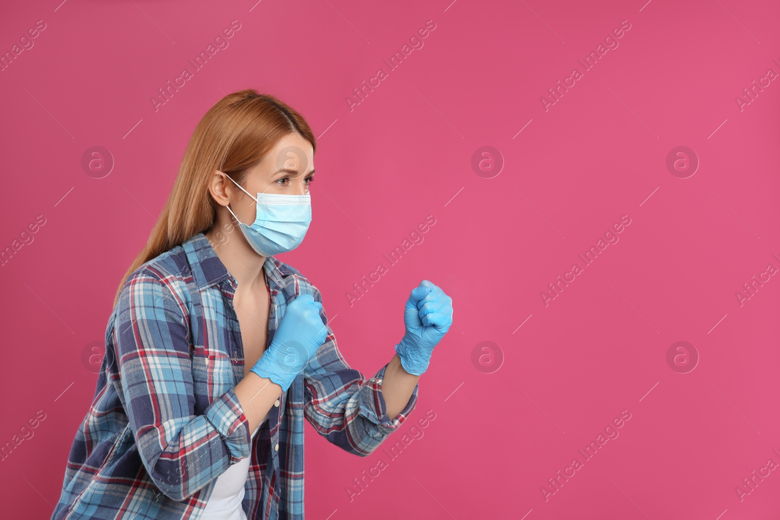 Photo of Woman with protective mask and gloves in fighting pose on pink background, space for text. Strong immunity concept