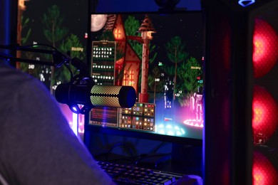 Photo of Man playing video games on computer at table indoors, closeup