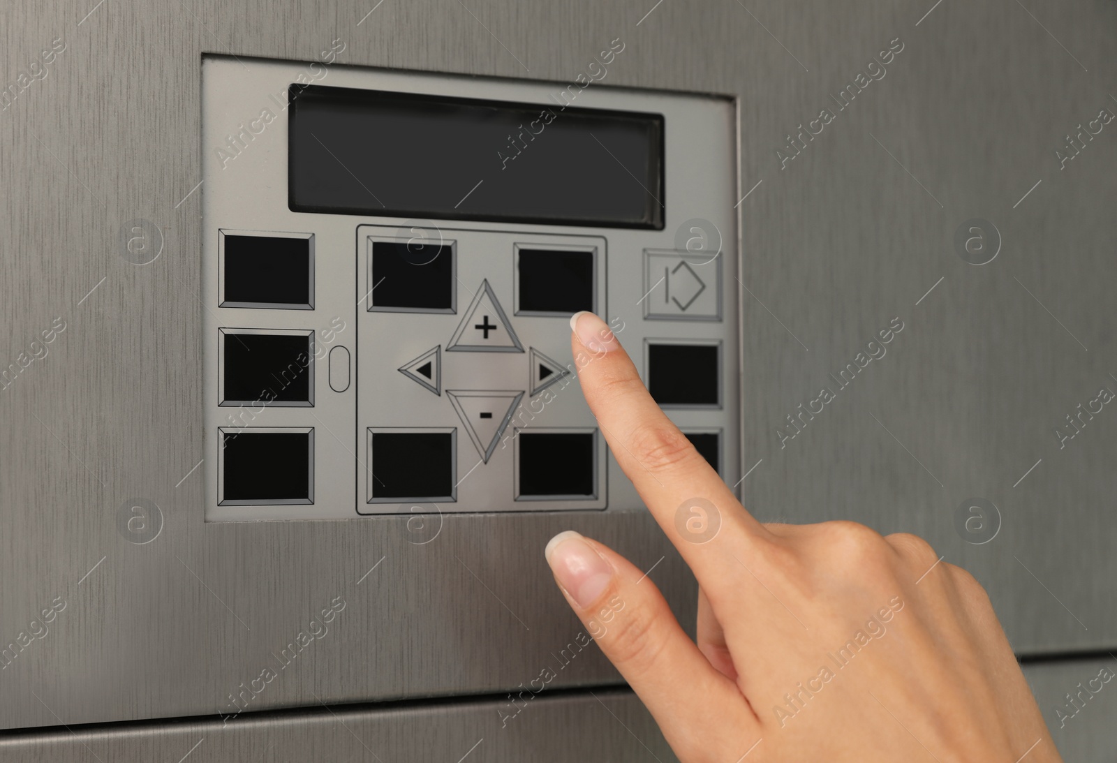 Photo of Young woman pressing buttons on washing machine in dry-cleaning, closeup