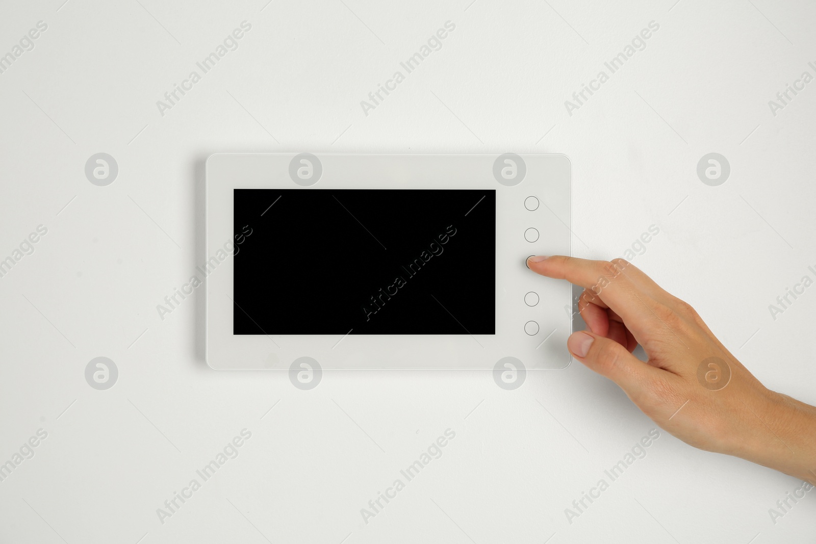 Photo of Woman using modern video intercom indoors, closeup