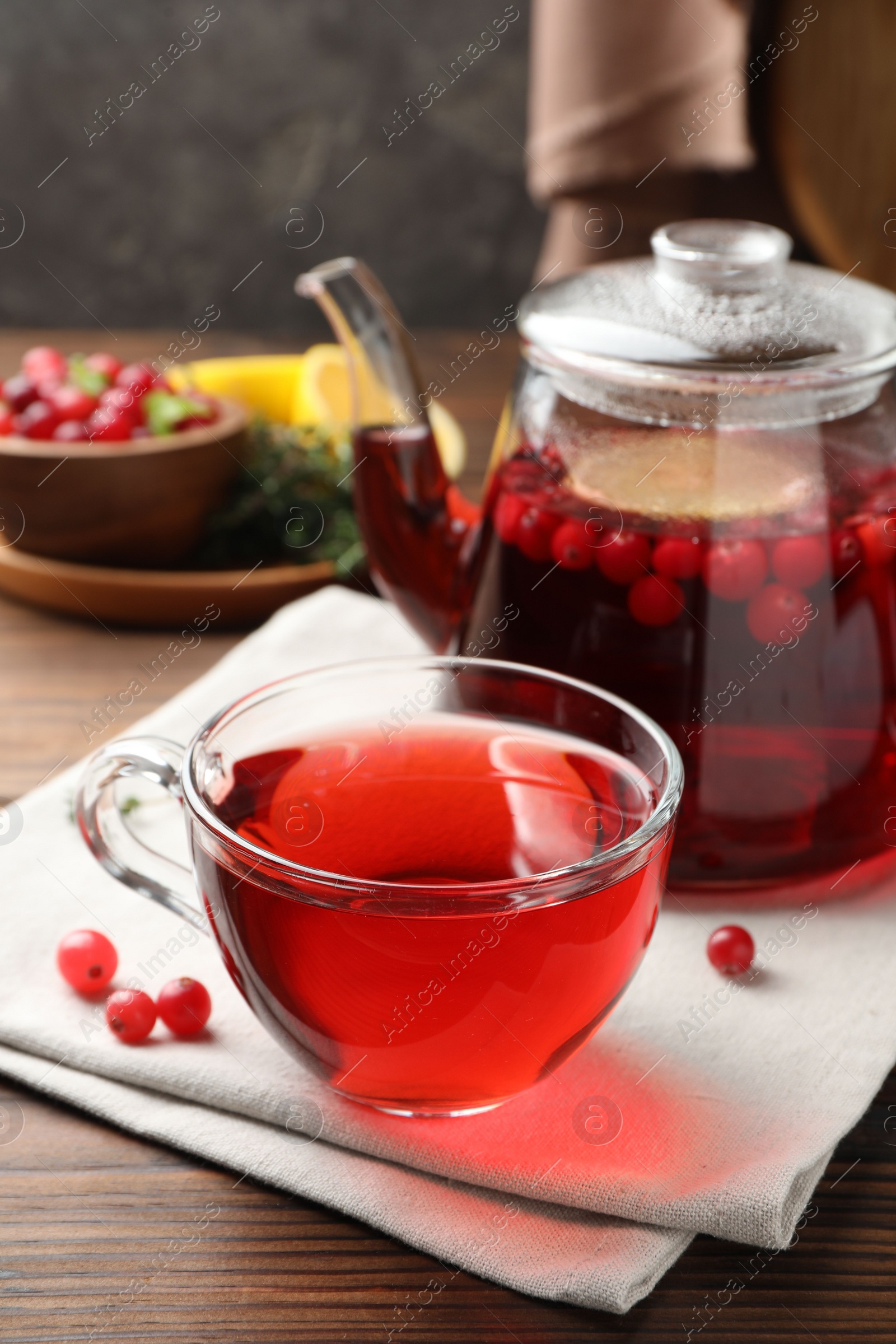 Photo of Tasty hot cranberry tea and fresh berries on wooden table