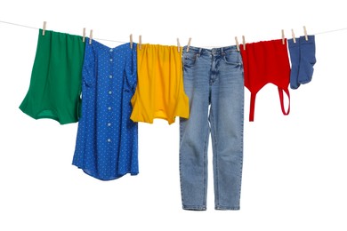 Different clothes drying on laundry line against white background