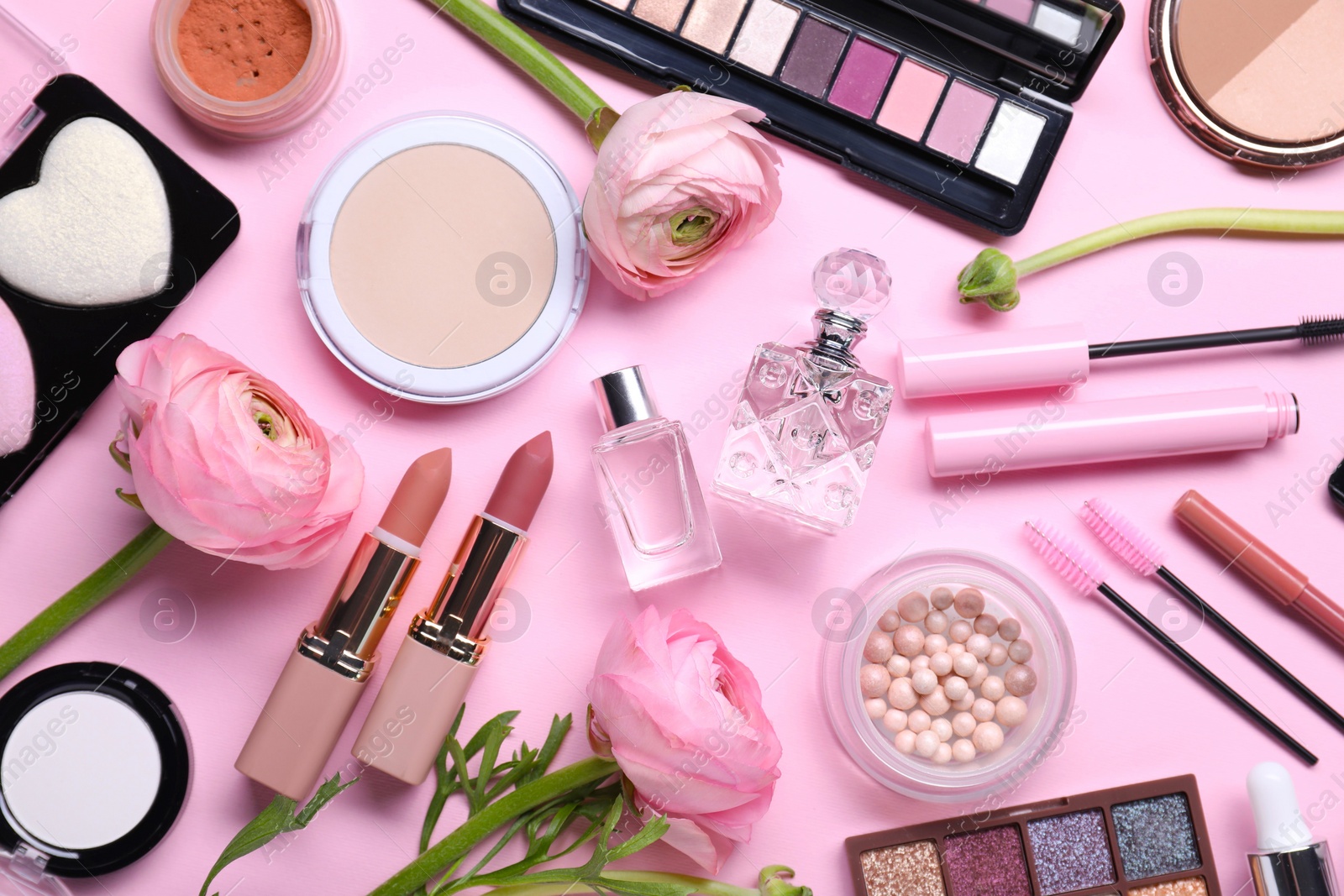 Photo of Flat lay composition with different makeup products and beautiful spring flowers on pink background