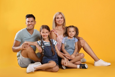 Portrait of happy family on yellow background