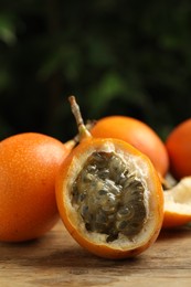 Photo of Delicious ripe granadillas on wooden table. Exotic fruit