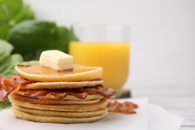 Delicious pancakes with bacon, butter and honey on table, closeup