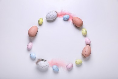 Photo of Frame made of many painted Easter eggs on white background, flat lay. Space for text