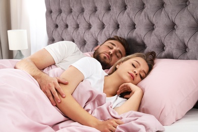 Photo of Young couple sleeping together in bed at home