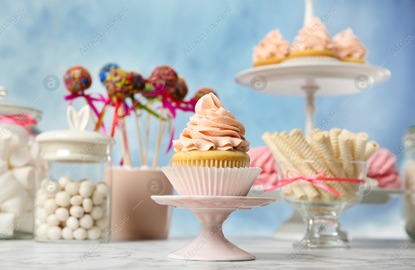 Photo of Candy bar with different sweets on white marble table against color background