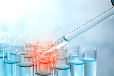 Dripping sample into test tube with liquid, closeup. Laboratory analysis