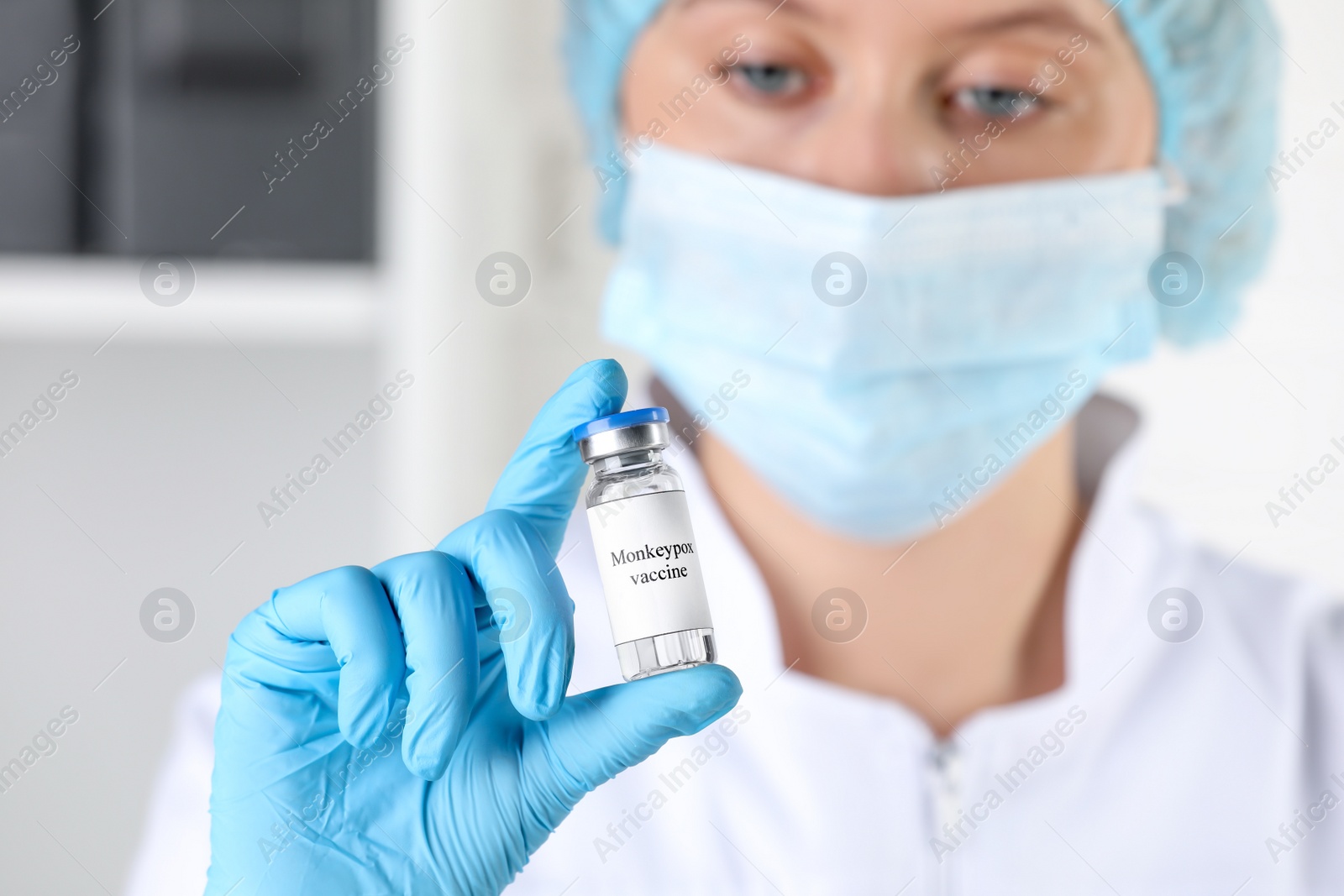 Photo of Nurse with glass vial of monkeypox vaccine in hospital, focus on hand