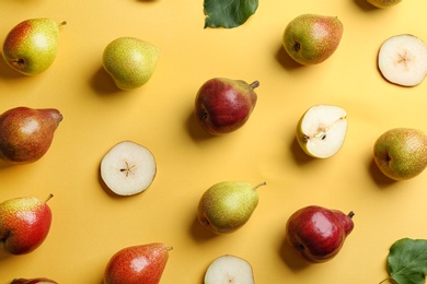 Ripe juicy pears on yellow background, flat lay