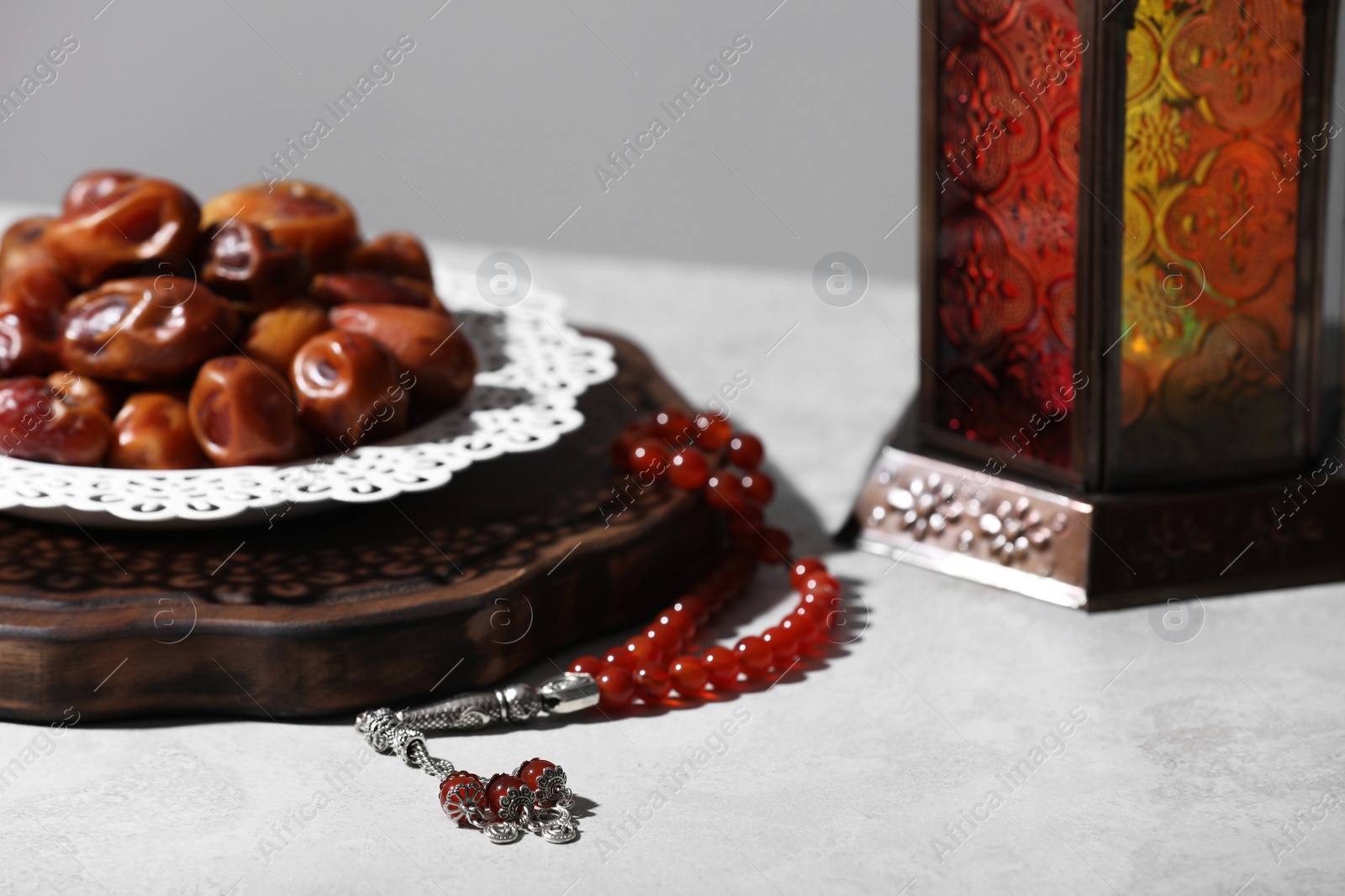 Photo of Board with dates, prayer beads and Muslim lamp on light table