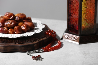 Photo of Board with dates, prayer beads and Muslim lamp on light table