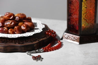 Board with dates, prayer beads and Muslim lamp on light table