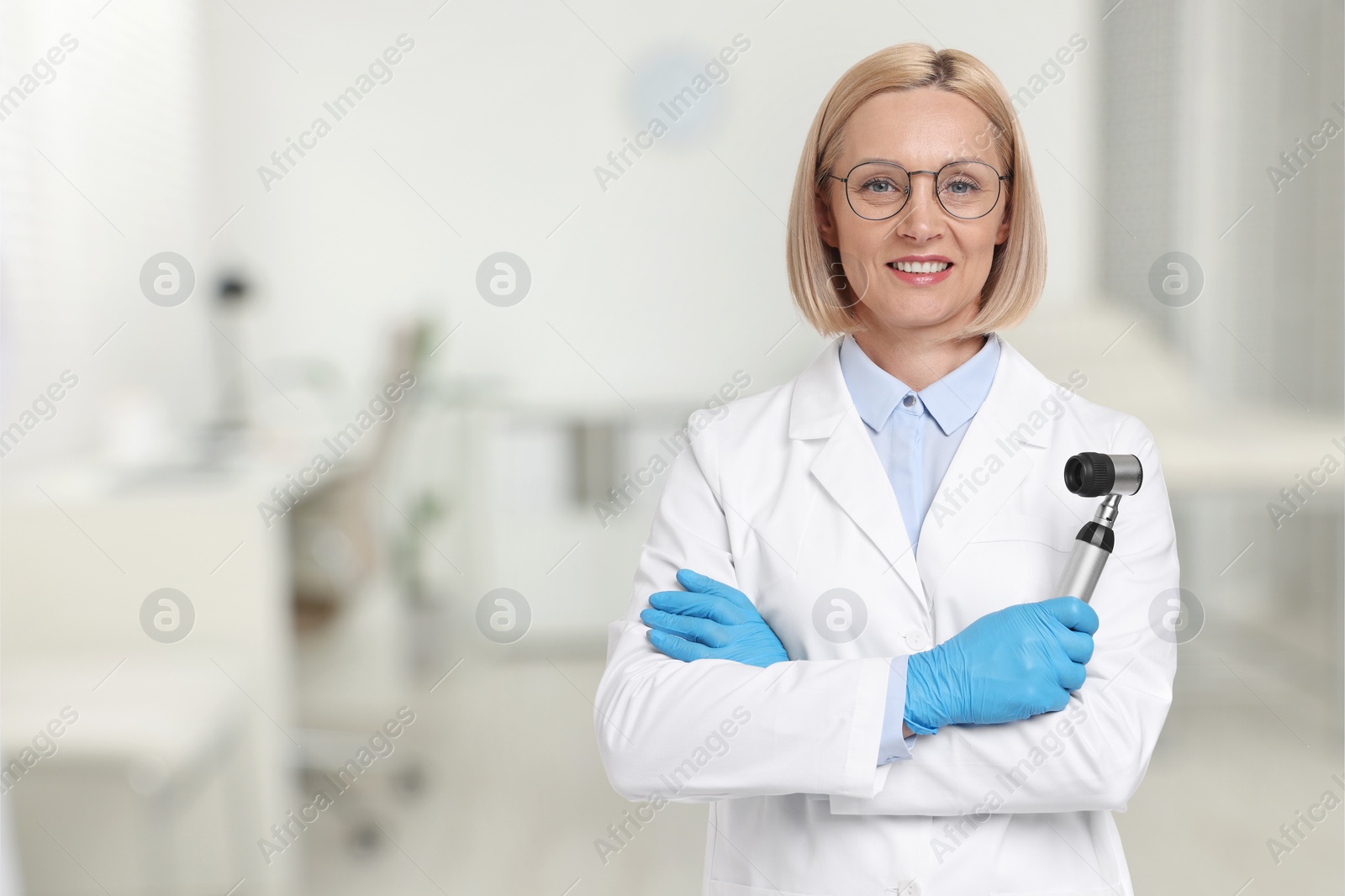 Image of Professional dermatologist with dermatoscope on blurred background, space for text