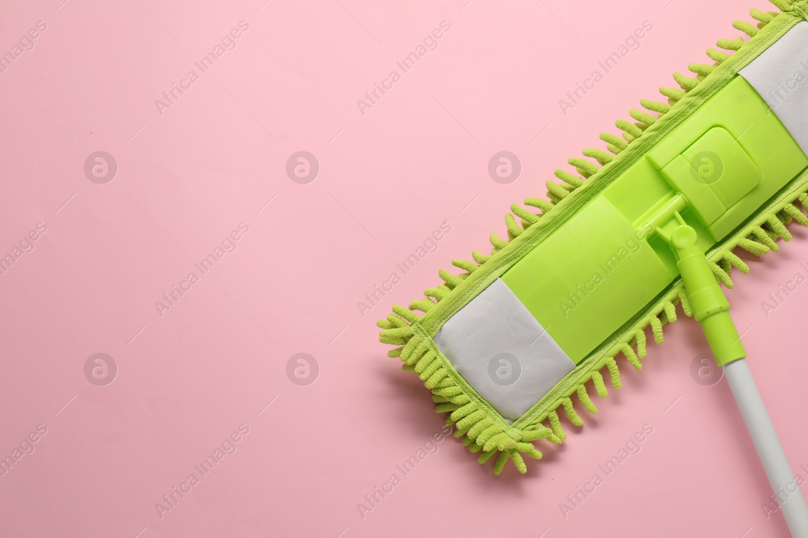 Photo of Mop with plastic handle on pink background, top view. Space for text