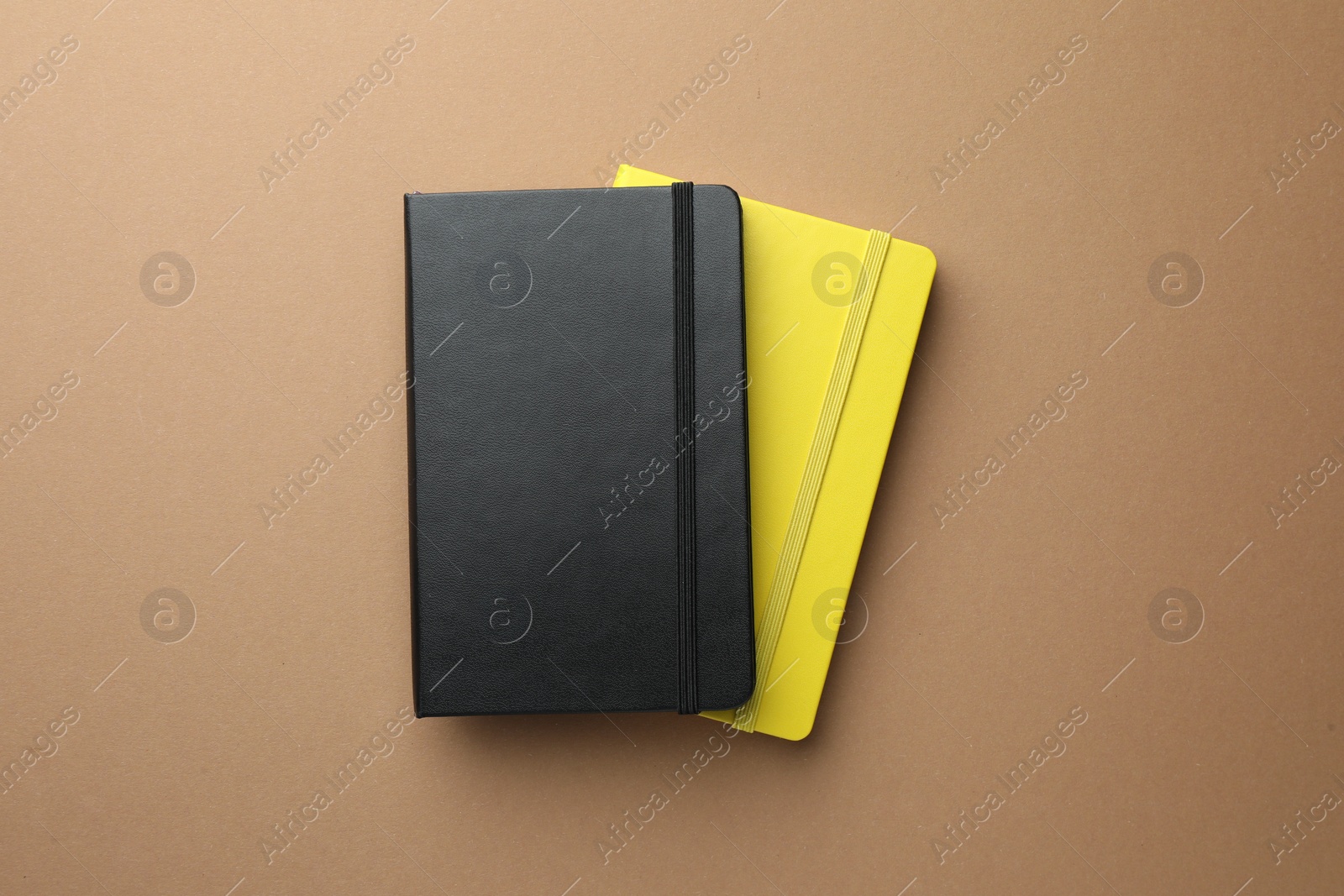Photo of Different notebooks on light brown background, top view