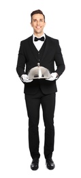 Handsome waiter holding metal tray with lid on white background