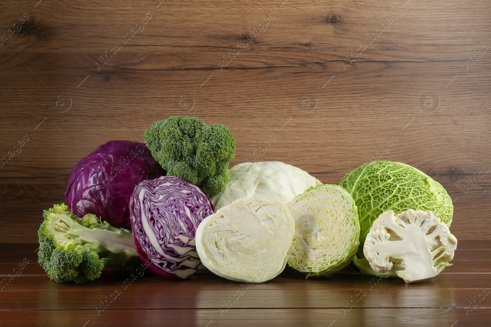 Photo of Different types of cabbage on wooden table