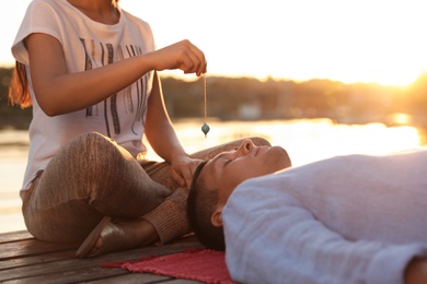 Photo of Man at crystal healing session near river outdoors