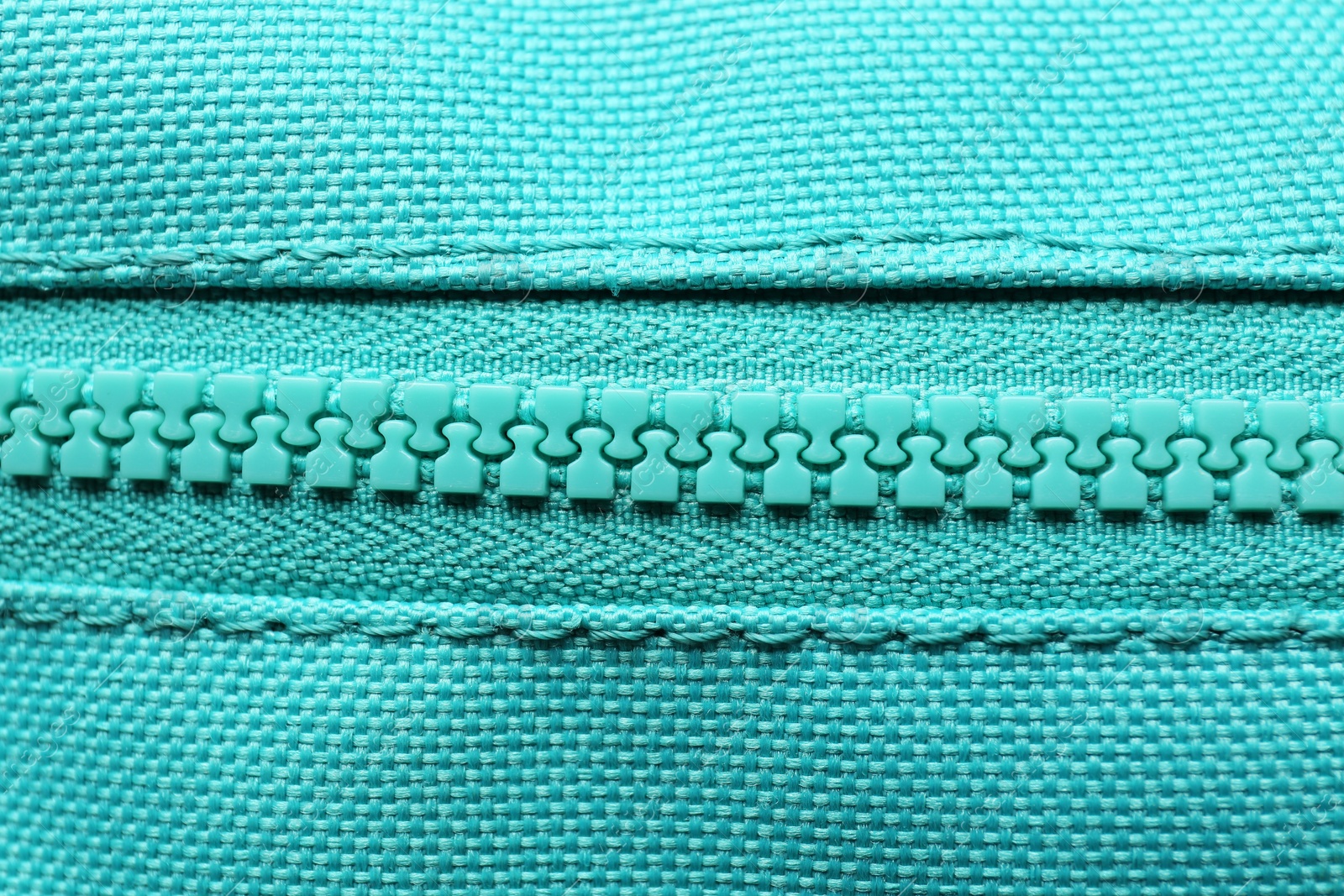 Photo of Turquoise fabric with zipper as background, closeup view