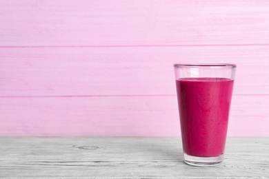 Glass with delicious detox smoothie on table