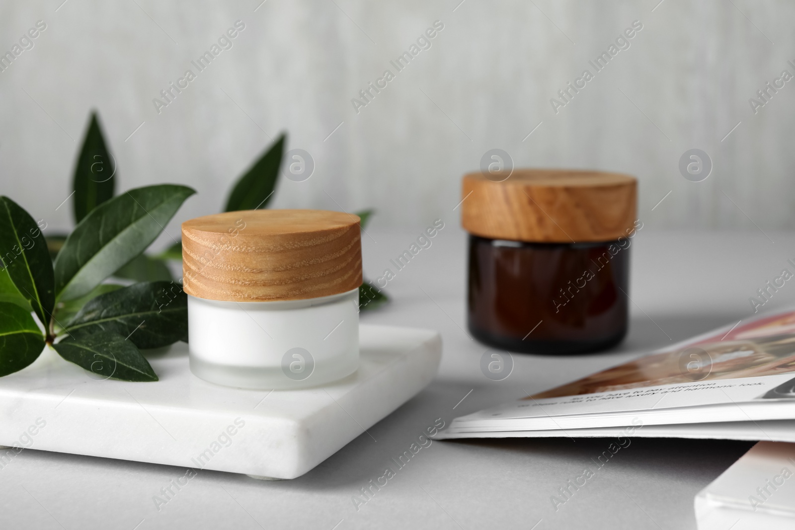 Photo of Jars with cream on white table, space for text. Cosmetic product