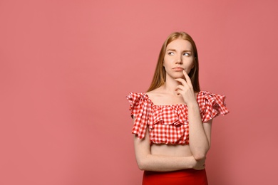 Photo of Portrait of thoughtful young woman on pink background, space for text