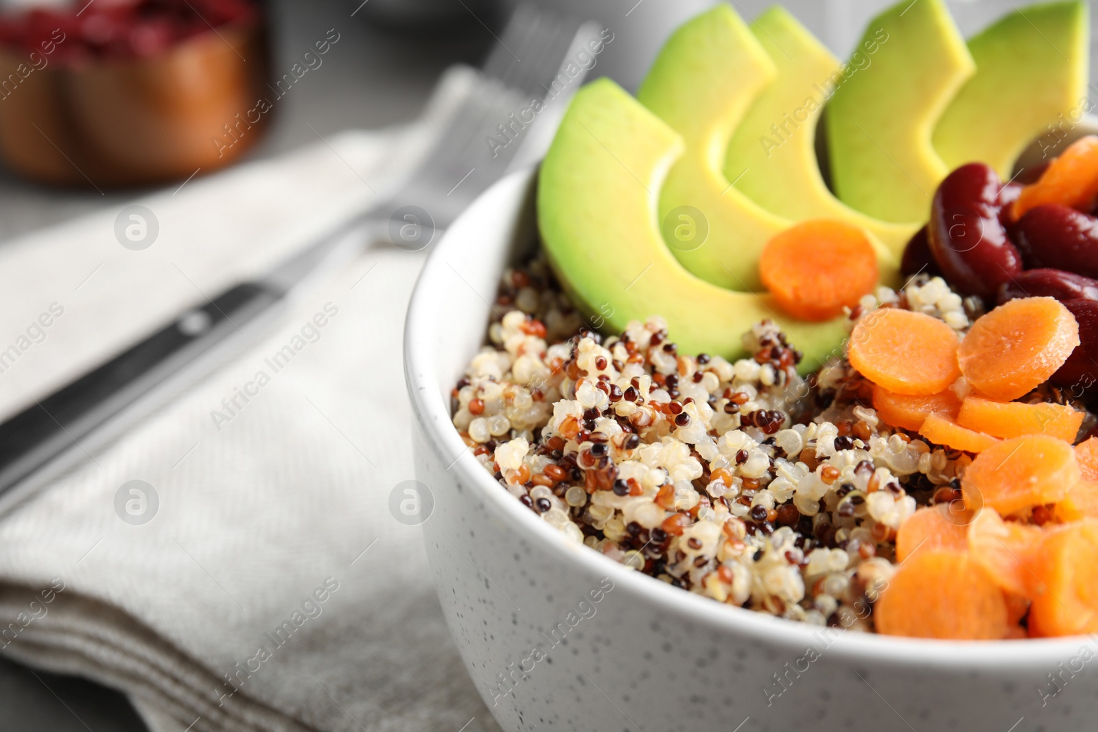 Photo of Healthy quinoa salad with vegetables in bowl on table, closeup. Space for text