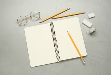 Photo of Flat lay composition with sketchbook, glasses and stationary on light grey table
