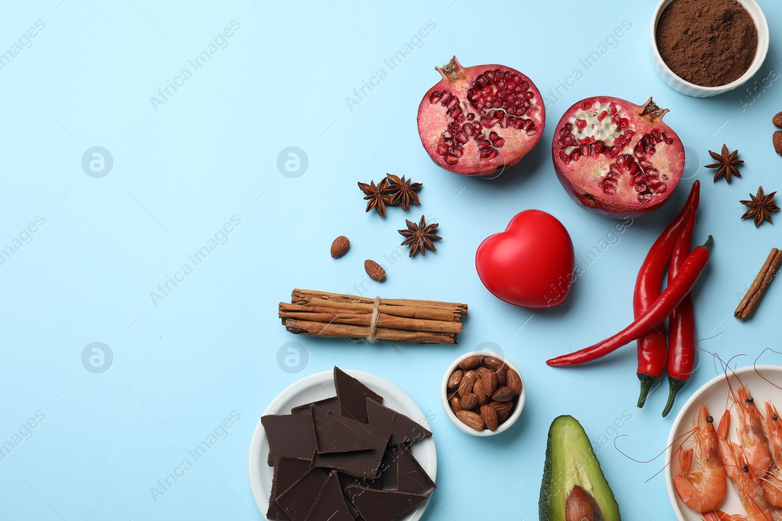 Photo of Natural aphrodisiac. Different products and heart model on light blue background, flat lay. Space for text