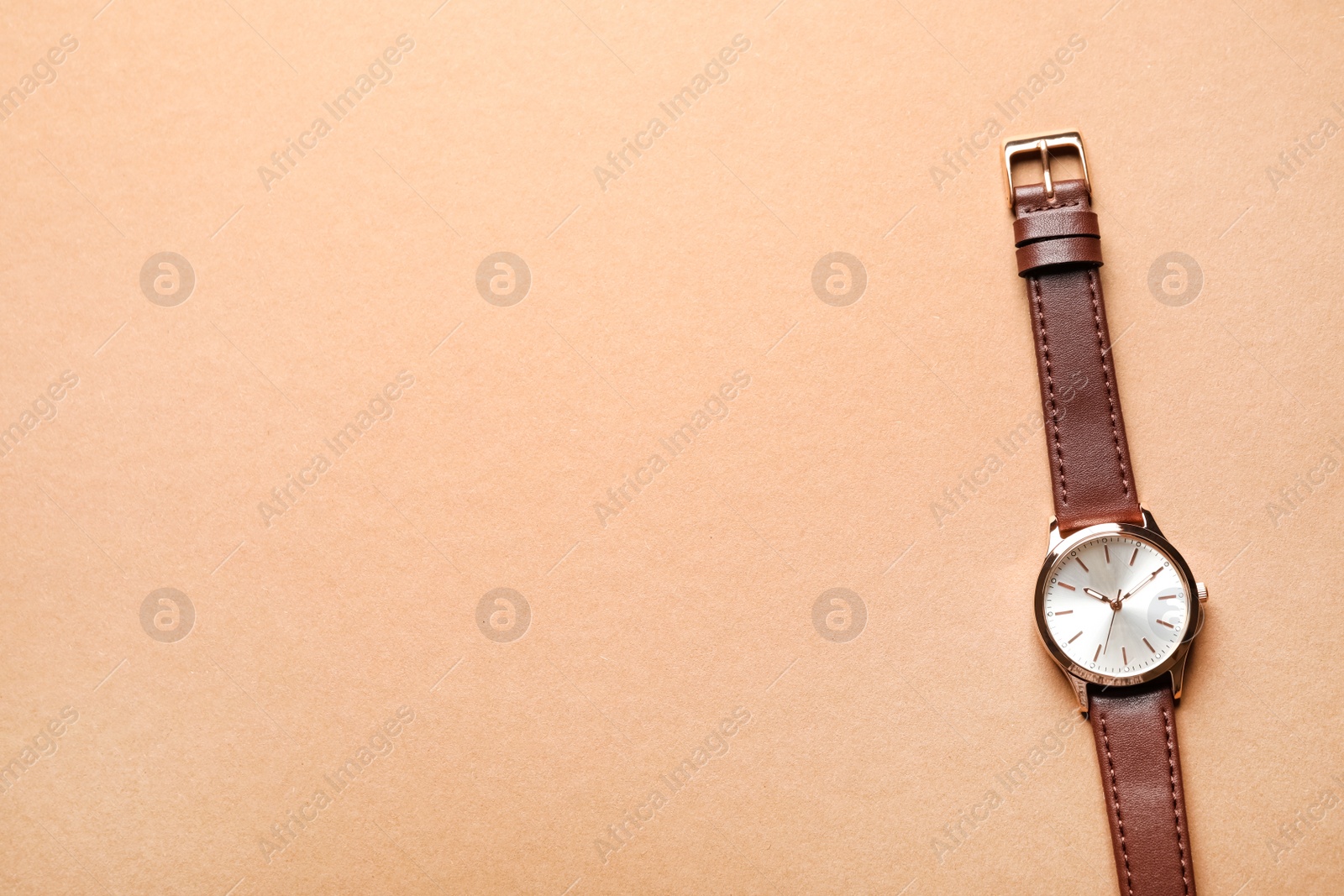 Photo of Luxury wrist watch on beige background, top view. Space for text