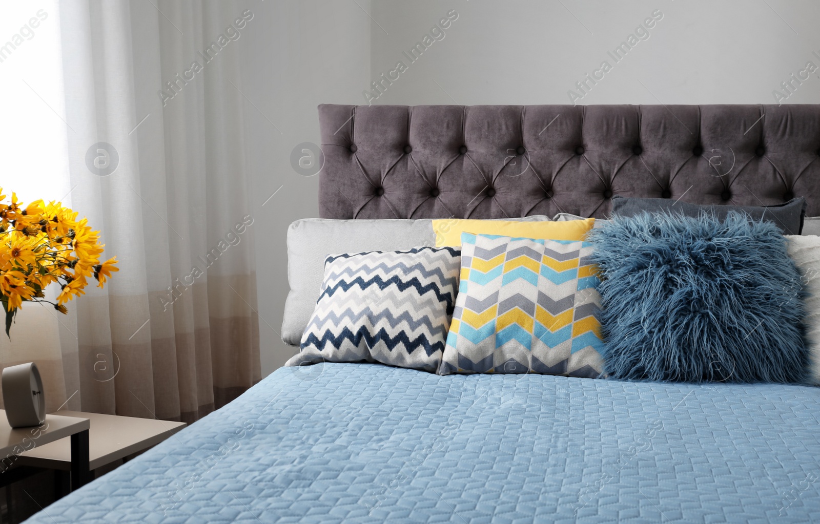 Photo of Different pillows on bed in room. Idea for interior decor