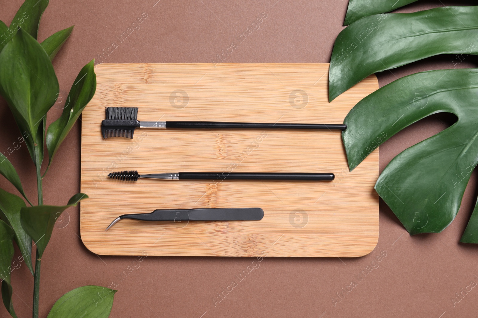 Photo of Flat lay composition with set for eyelash extension tools on brown background