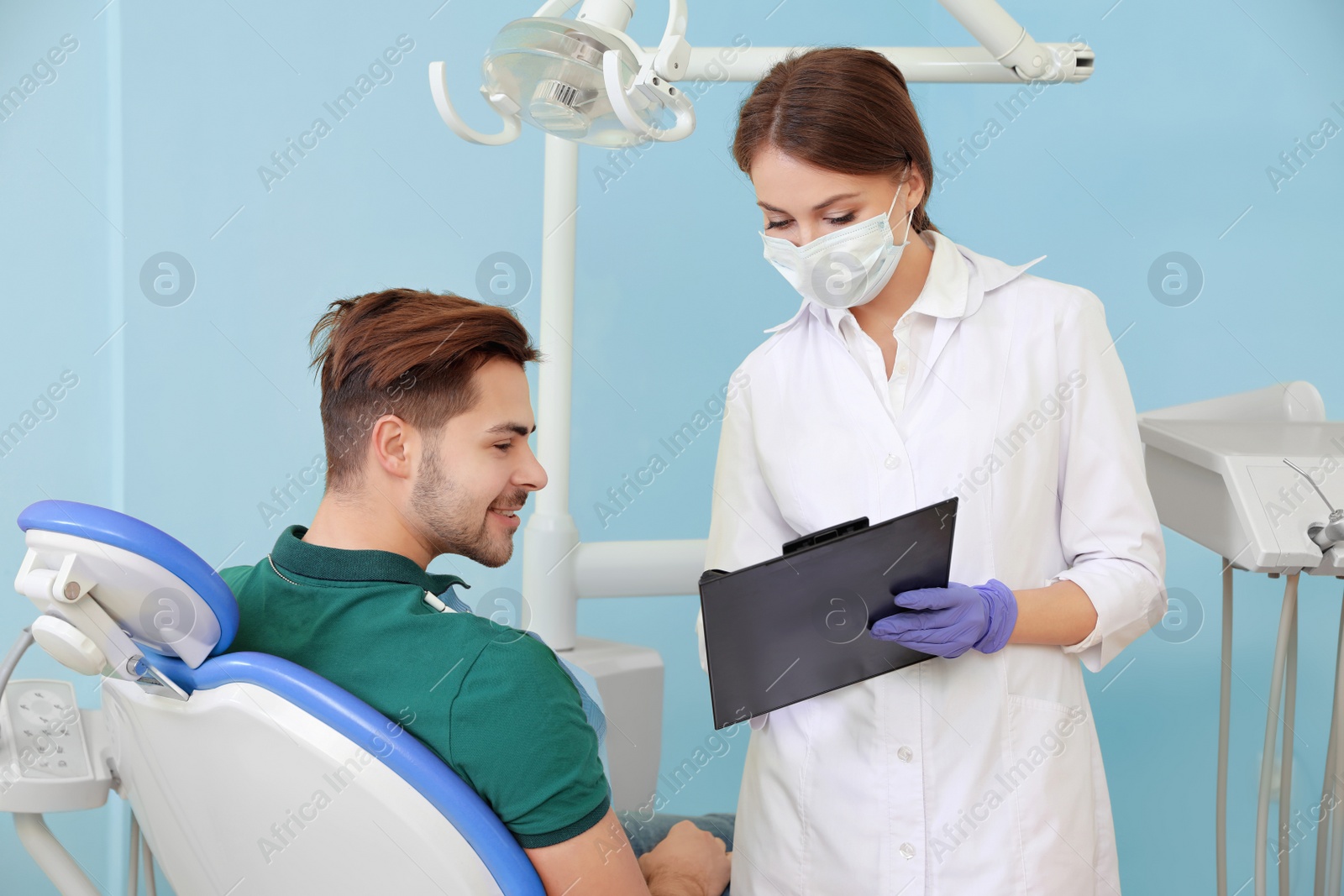 Photo of Professional dentist and patient in modern clinic