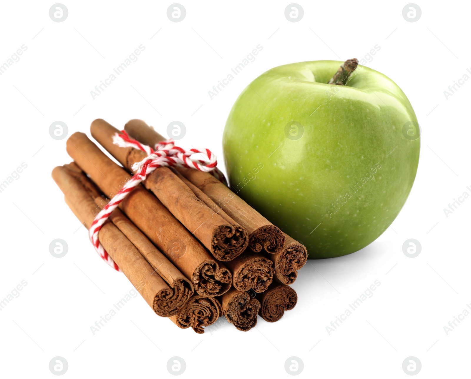 Photo of Cinnamon sticks and green apple on white background