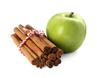 Cinnamon sticks and green apple on white background